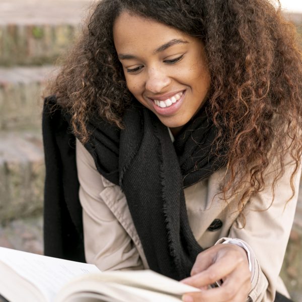 front-view-curly-woman-reading-outdoors